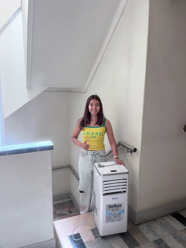 Renata, fundadora da AC Rental Lisbon, ao lado de um ar condicionado portátil pronto a entregar